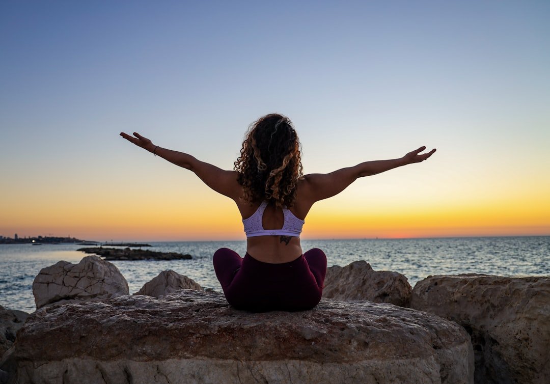 A serene scene depicting a person practicing mindfulness or yoga in a peaceful outdoor setting, symbolizing wellness and relaxation.